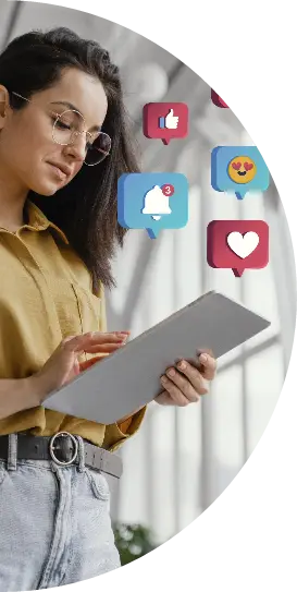 Woman in glasses using a tablet with floating social media icons like hearts and thumbs up, representing digital marketing services offered by a top agency in Kochi, Kerala.