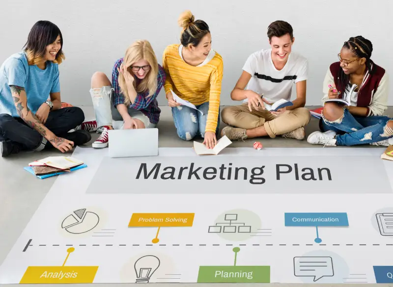 A group of diverse professionals sitting on the floor, collaborating on a marketing plan, illustrating the ethical and transparent practices of Techpullers' tailored social media marketing strategies.