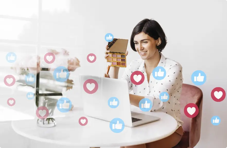 A woman creating social media content on a laptop, surrounded by floating like and heart icons, representing social media strategy development services by Techpullers.