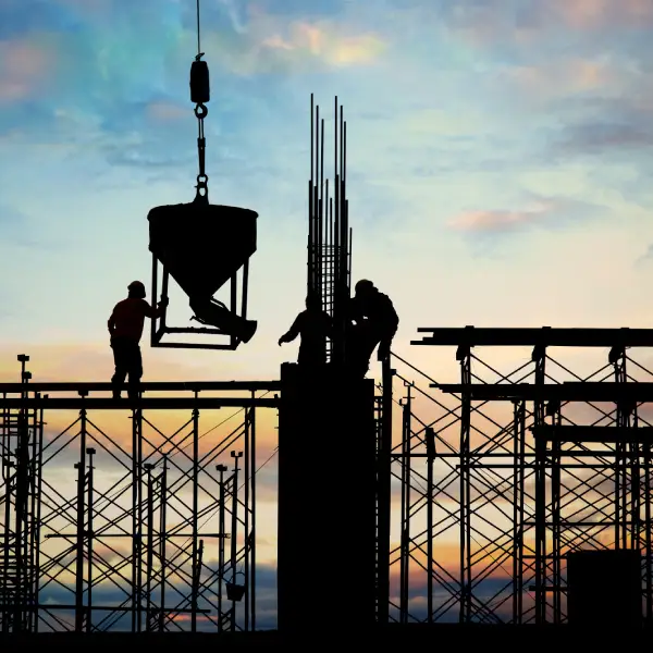 Construction workers at a building site during sunset, illustrating TechPullers' web solution for Olive Builders, highlighting urban lifestyle options.