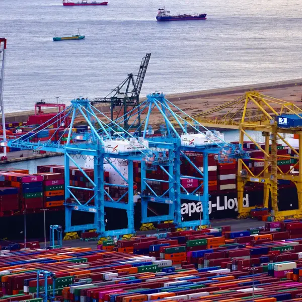 Cargo containers and cranes at a port, showcasing TechPullers' web development for QT Container Line, enhancing online presence for international business visibility.