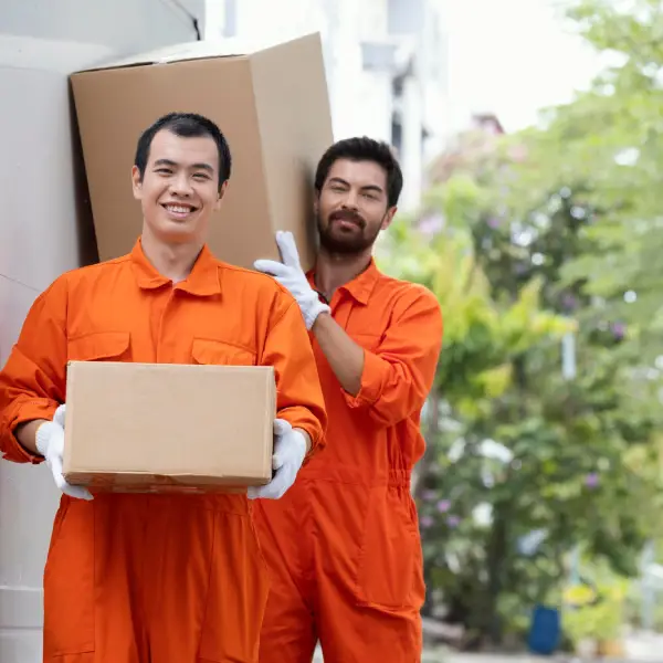 Movers in orange uniforms carrying boxes, illustrating TechPullers' development of an online platform for Realtime Packers & Movers, a Dubai-based moving company, enhancing operational efficiency and customer reach.