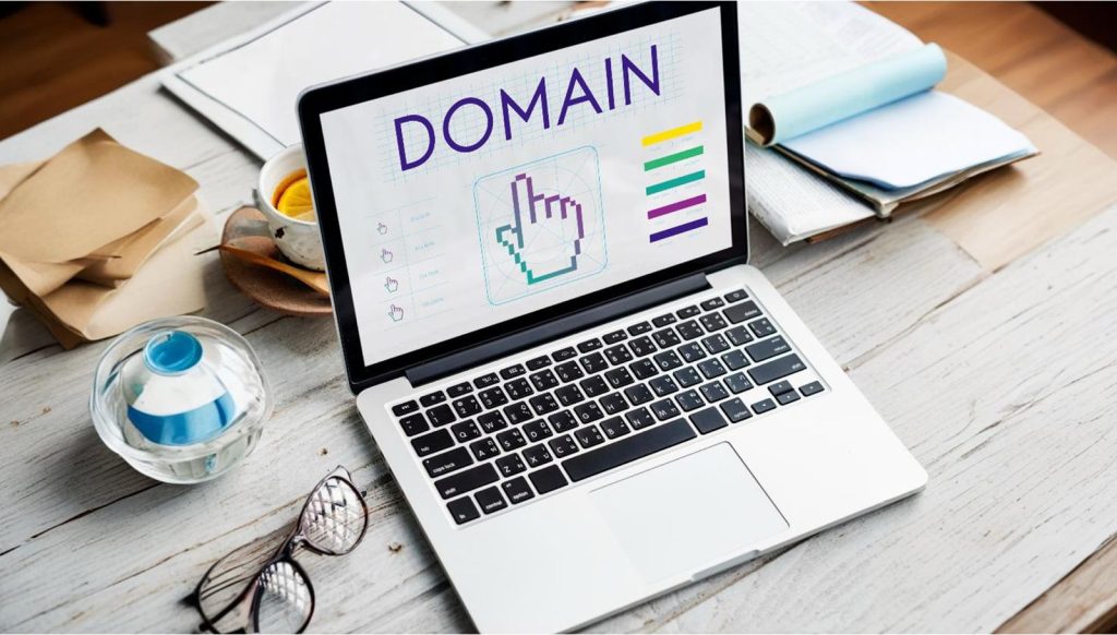 Laptop screen displaying the word 'DOMAIN' with a cursor icon