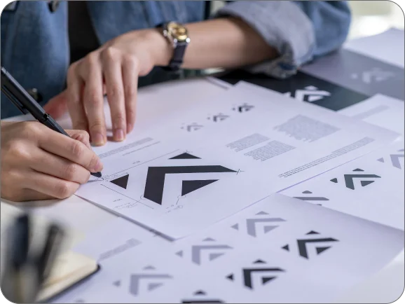 Connected design and branding services - designer working on logo concepts and graphic elements for professional web design, branding, and digital strategy.